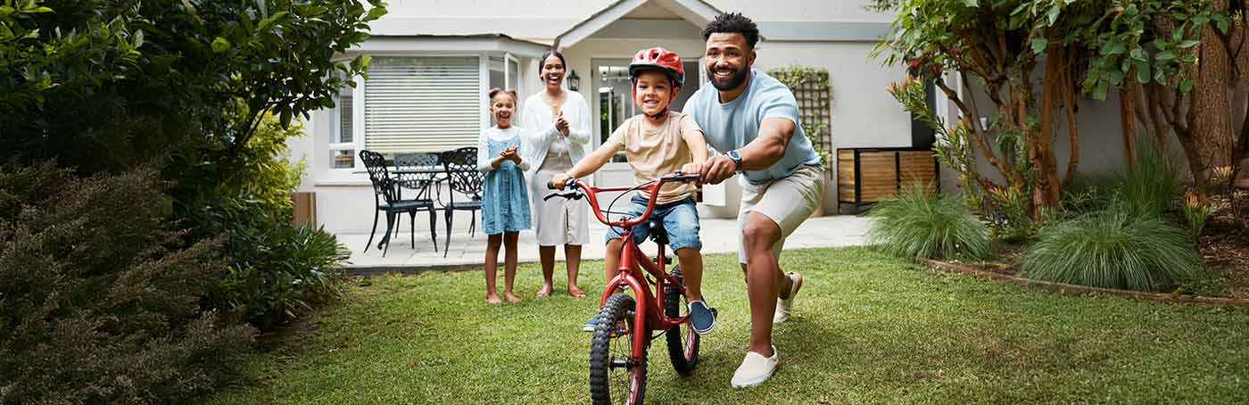 father helping son ride a bike