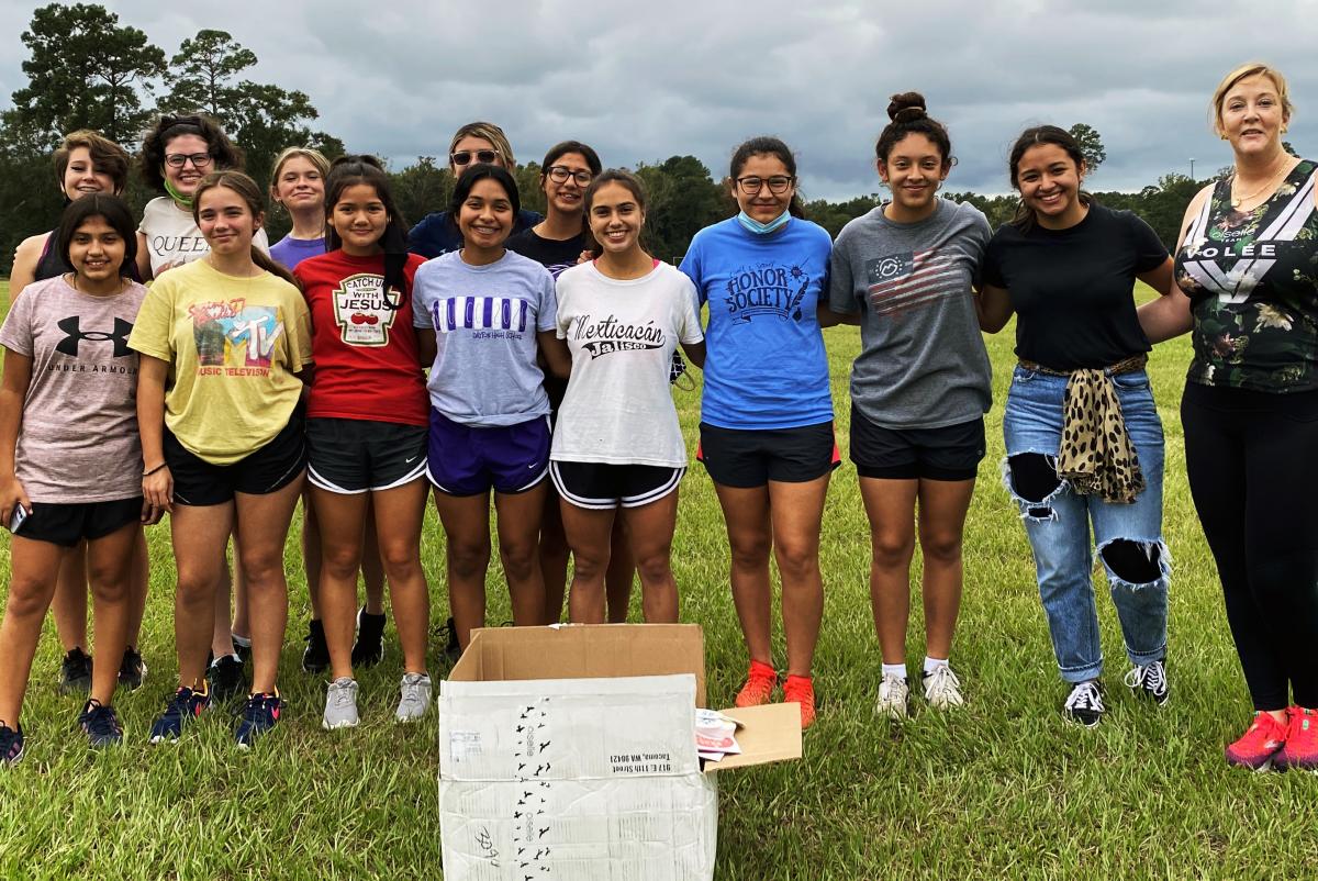 Former DCDC Intern Sarahi Plascencia (second from right) and DCDC Executive Director Ann Marie Miller (right) present the Dayton